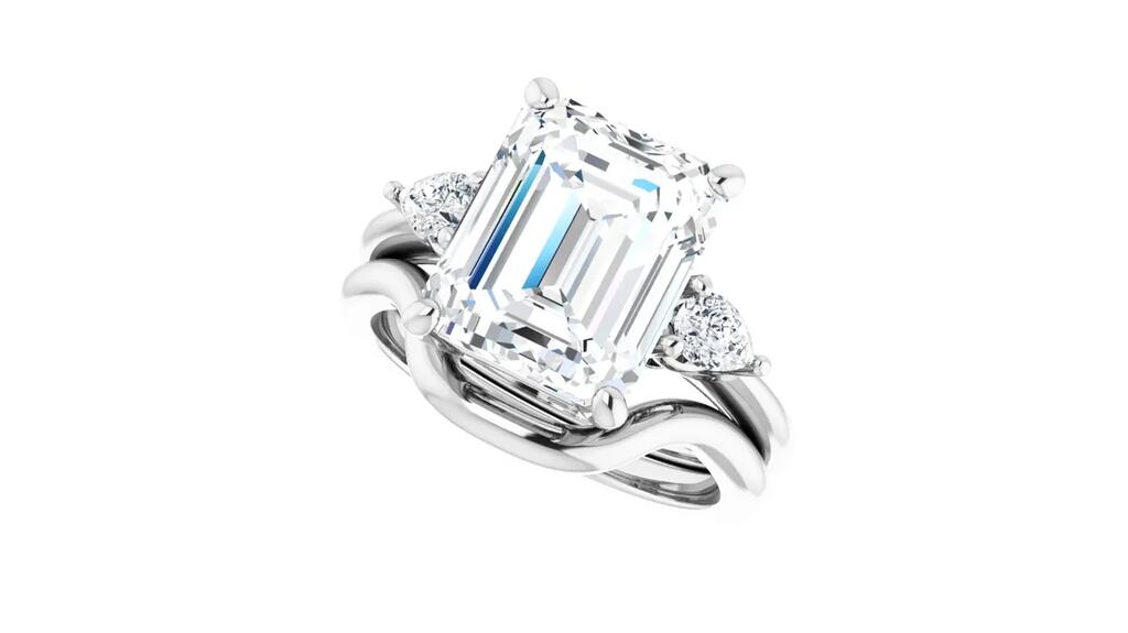 This engagement ring style from the “ever & ever” line exemplifies three trends in bridal: elongated-shaped diamonds for center stones (the diamond here is an emerald cut), three-stone rings, and three-stone rings with fancy-shaped side stones (pears here). Stuller engagement ring